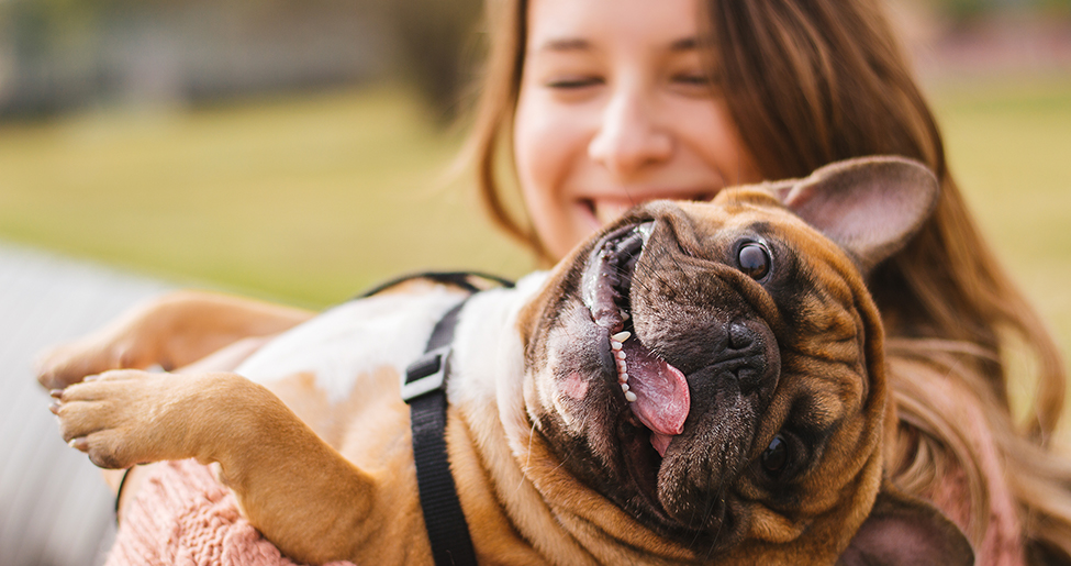 Close-up of women smiling with a dog across her