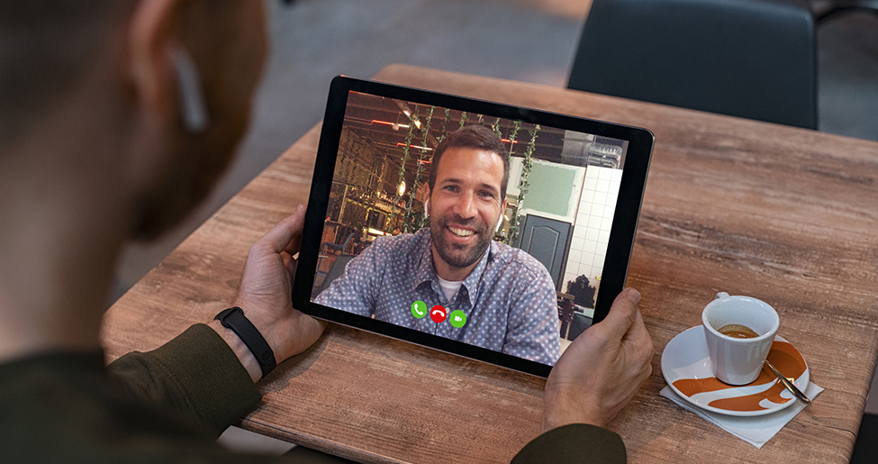 remote meeting taking place someone looking at a screen with a man's face on a video call