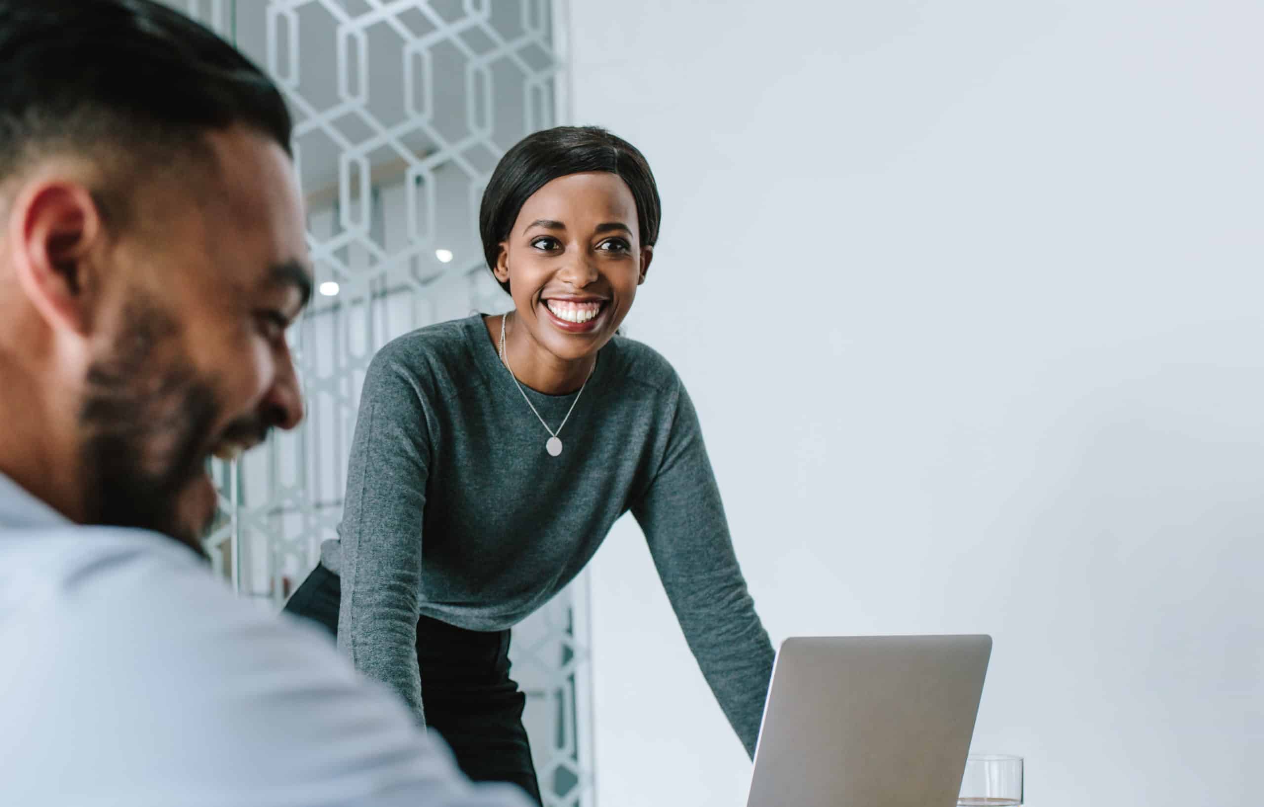 Female and male colleague looking at laptop screen of application forms