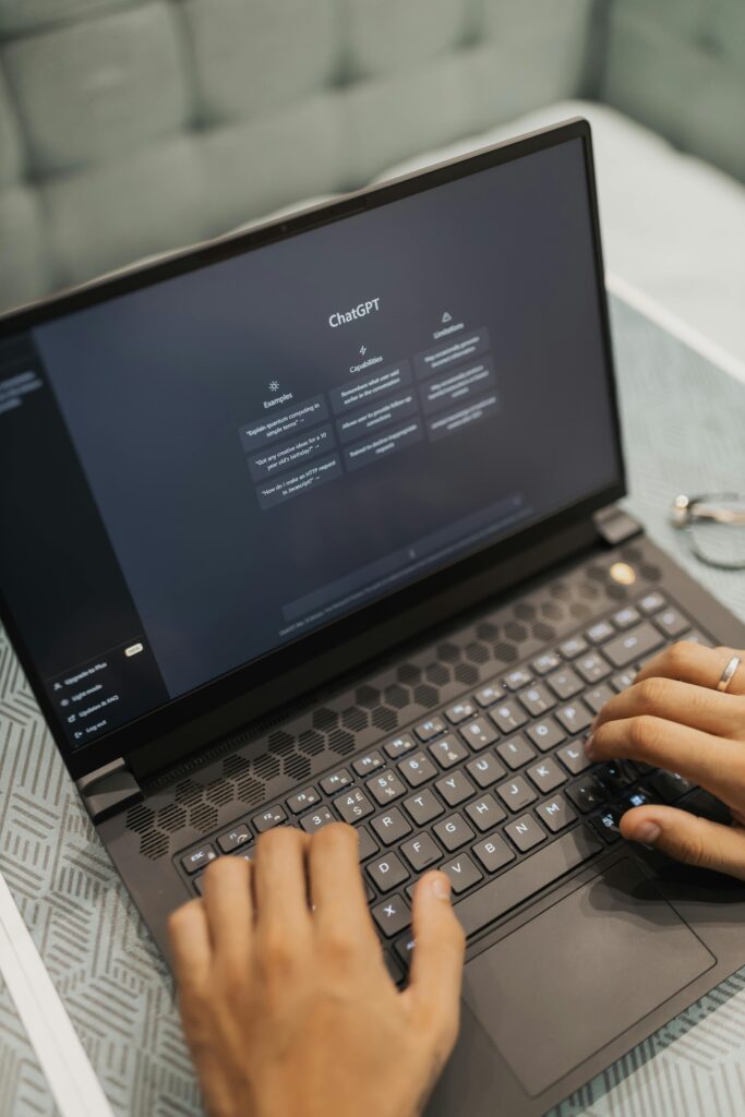 Hands of person typing on a laptop with a black screen with lists of white text