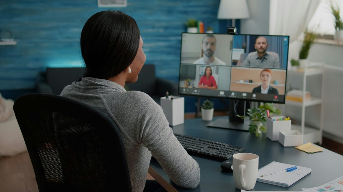 A woman being interviewed by a panel via a conference call.